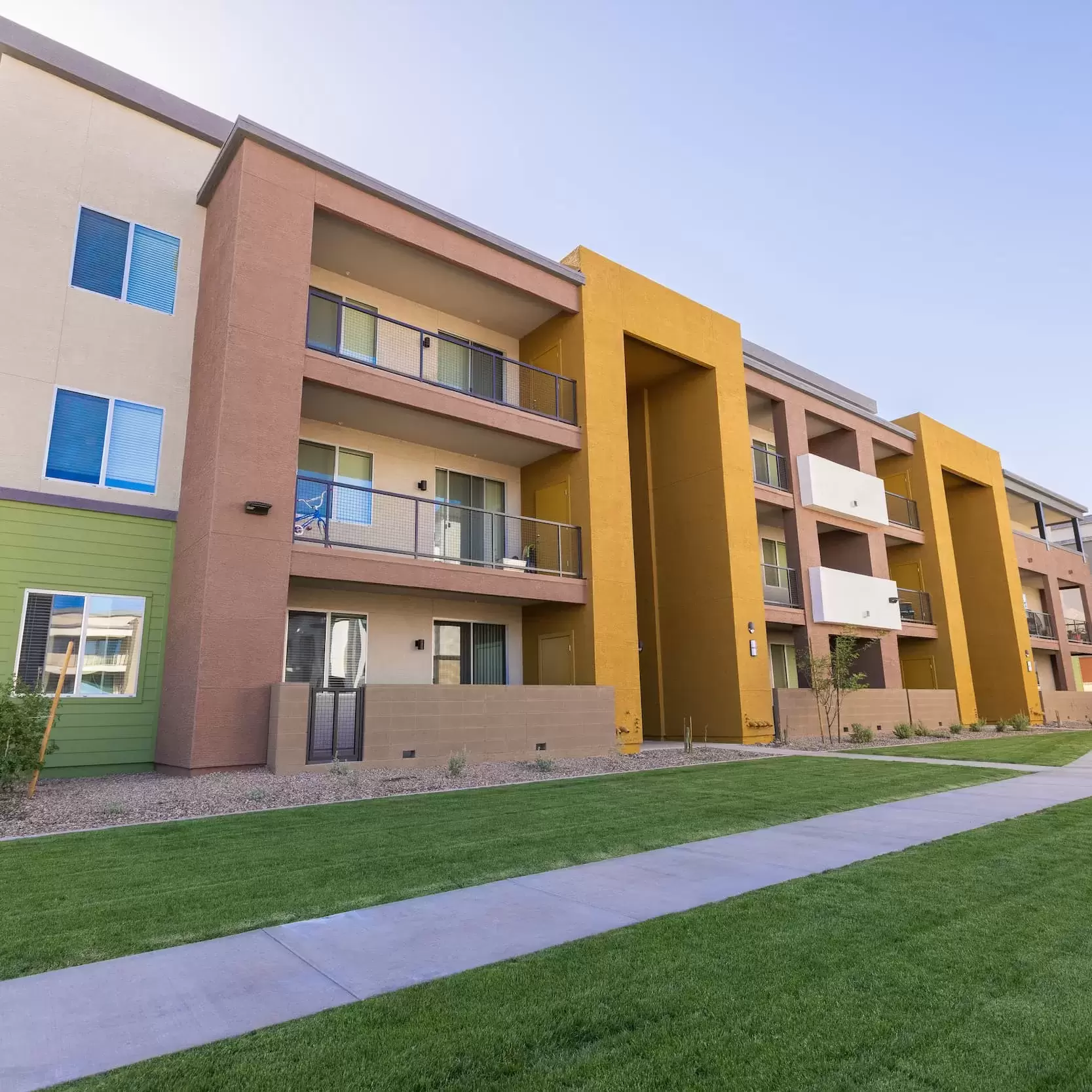 A view of the exterior of Liv Crossroads apartment buildings with a manicured lawn and tidy landscaping.