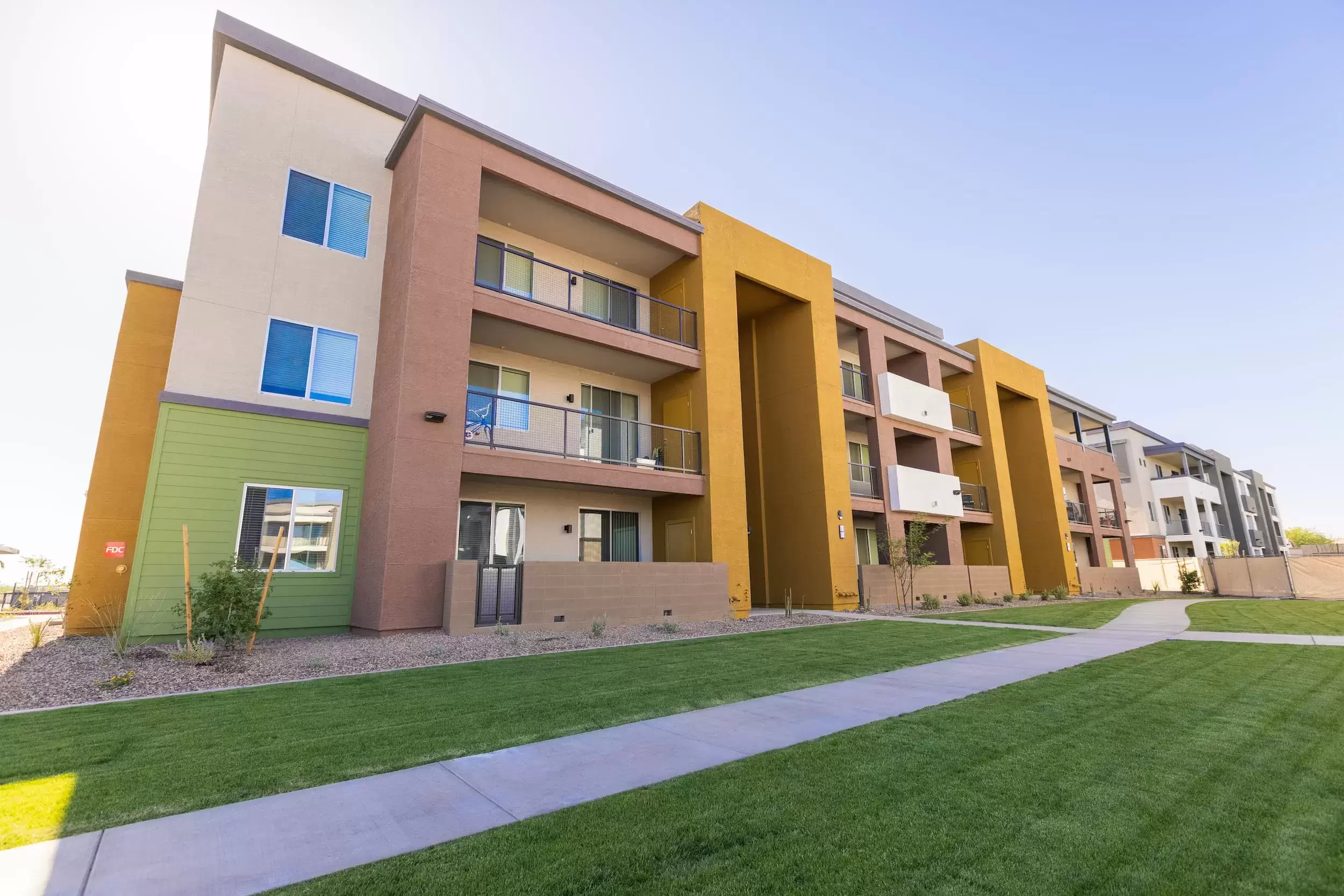 A view of the exterior of Liv Crossroads apartment buildings with a manicured lawn and tidy landscaping.