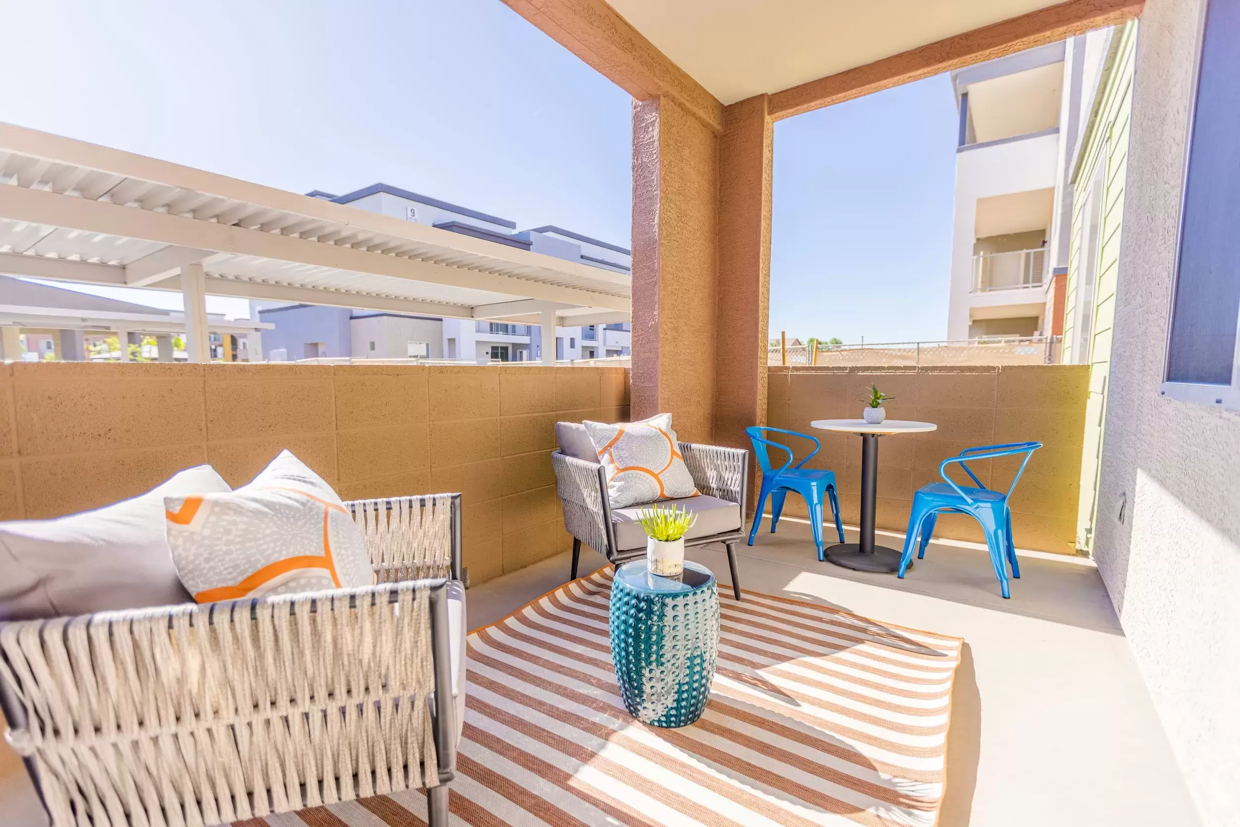 The balcony off an apartment at Liv Crossroads, with comfortable patio furniture and plenty of sunshine.